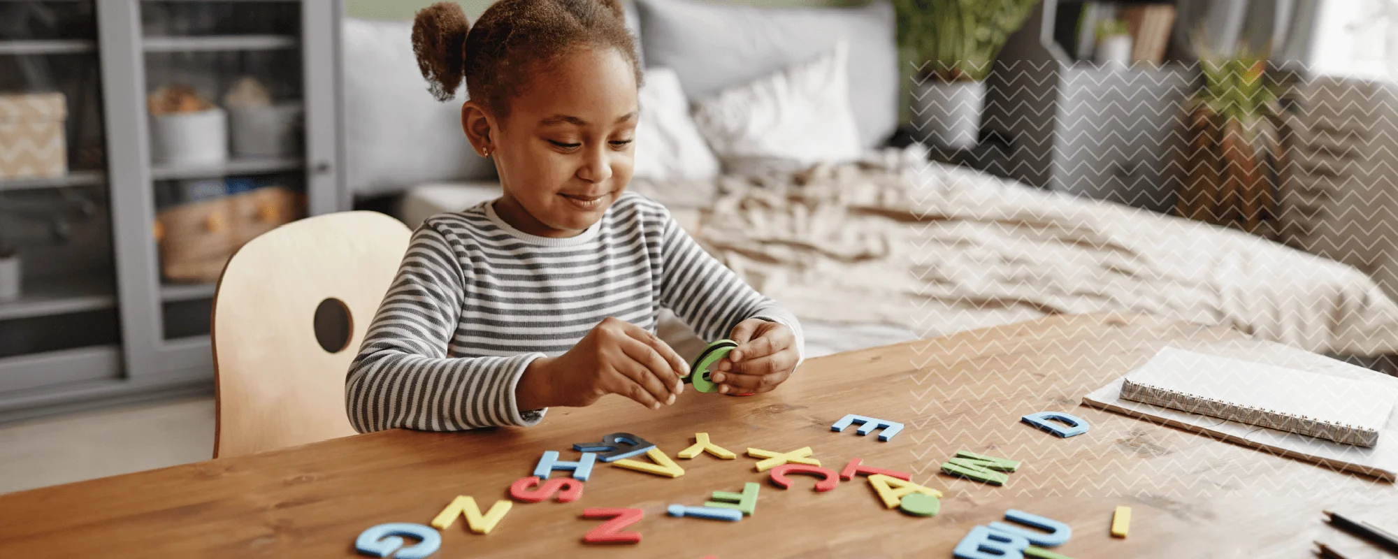 Niña jugando con letras de colores durante una actividad de estimulación cognitiva, asociada a trastornos del neurodesarrollo