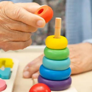 Persona mayor realizando actividad de estimulación cognitiva con materiales manipulativos; curso de Estimulación Cognitiva en Demencias de IEN